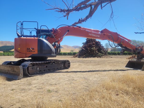 14-tonne excavator stacking demolition waste for removal