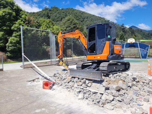 Excavator with breaker attachment demolishing concrete skate ramps, Picton